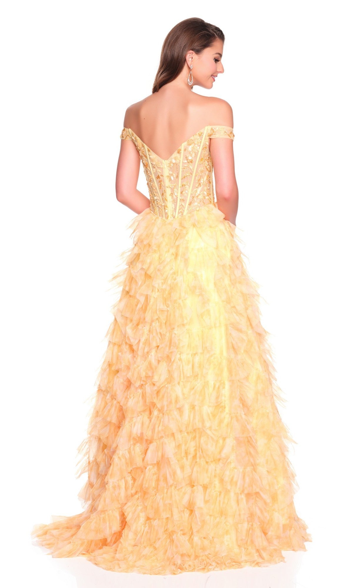 A woman in a Dave and Johnny 12767 long prom dress stands with her back to the camera, highlighting the off-the-shoulder yellow gown’s detailed bodice and full, ruffled tulle a-line skirt.
